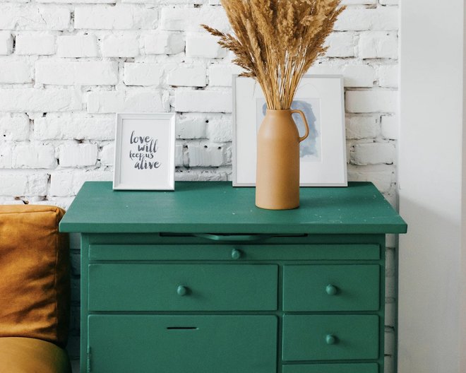 Green drawer with photo frames and a plant pot