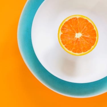 A white plate with an orange with an orange background